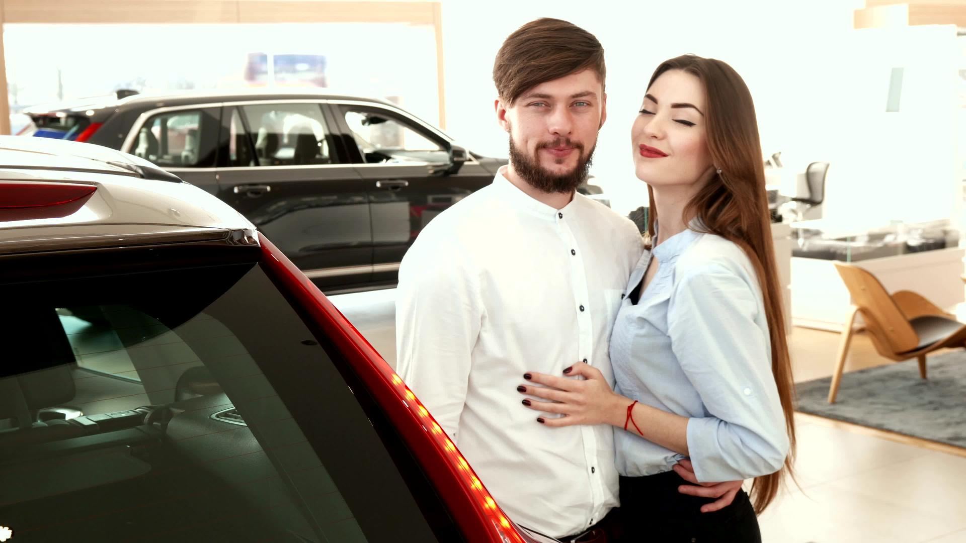 这对夫妇在经销商的汽车旁拥抱视频的预览图