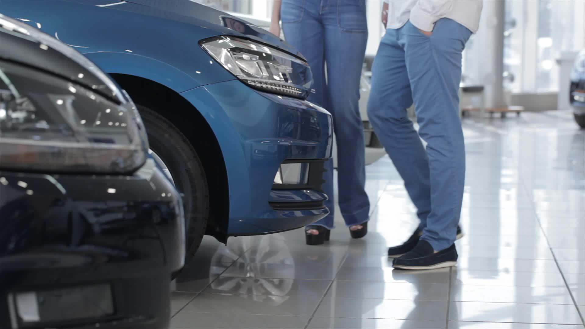 情侣们站在蓝色汽车旁边视频的预览图
