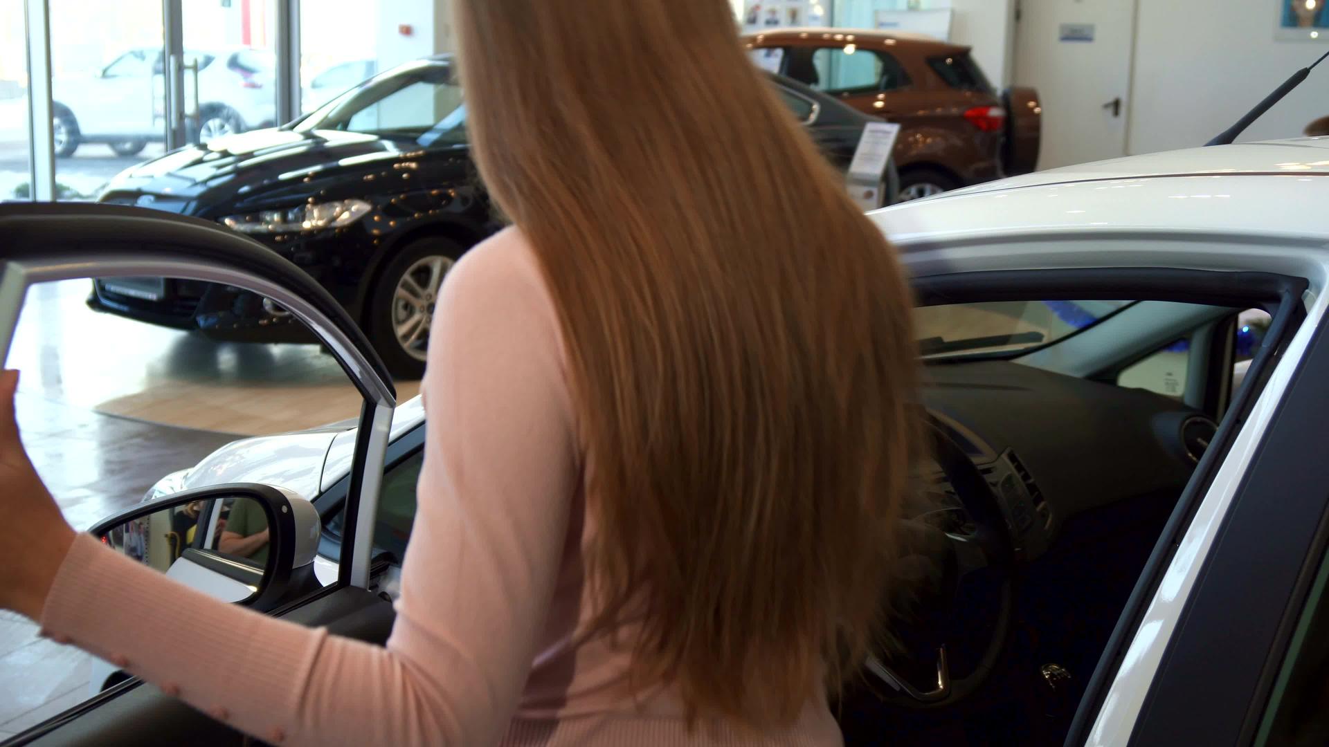 女人坐在汽车里在经销店视频的预览图