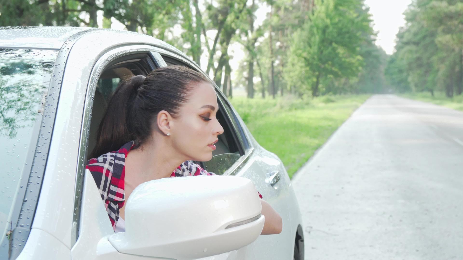 坐在车里的年轻女士在乡间公路上环顾四周视频的预览图