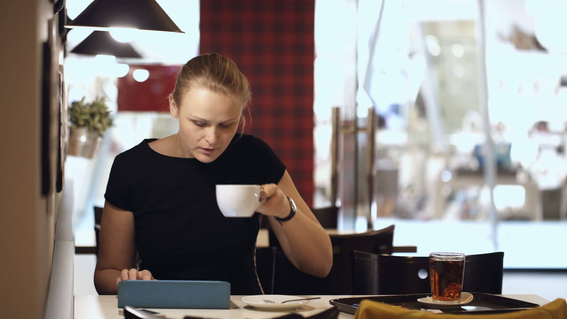 坐在咖啡馆里的年轻女性有垫子和咖啡视频的预览图