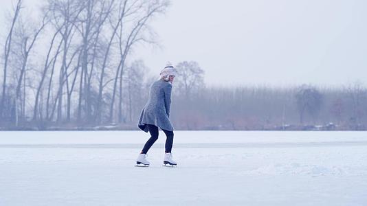 在冰冻湖的冰上滑冰年轻迷人的女人视频的预览图