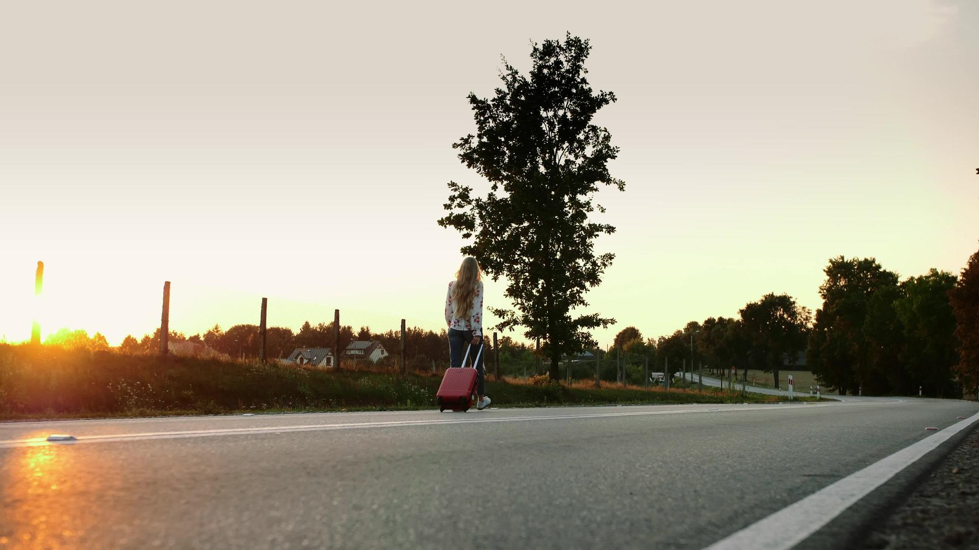 快乐的女人带着手提箱走在路上视频的预览图