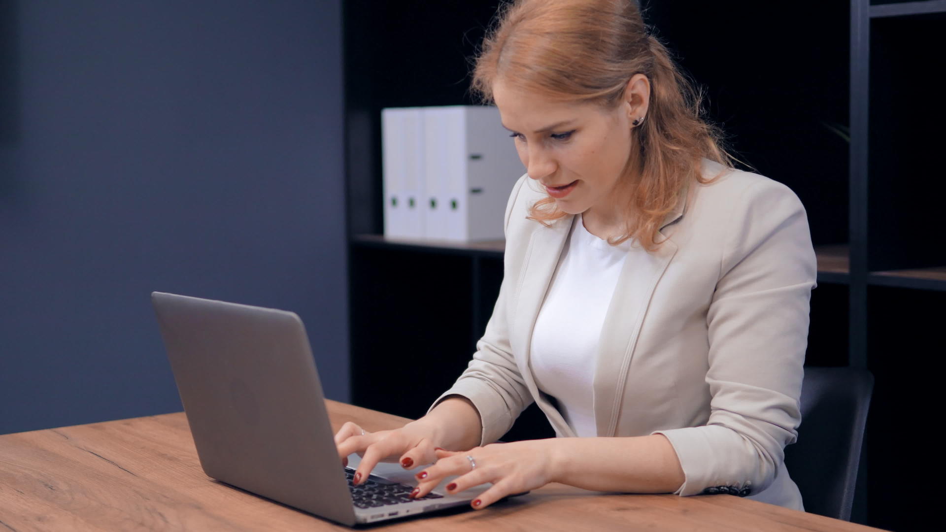 自信的中年女性专注于用笔记本电脑在桌子上工作视频的预览图