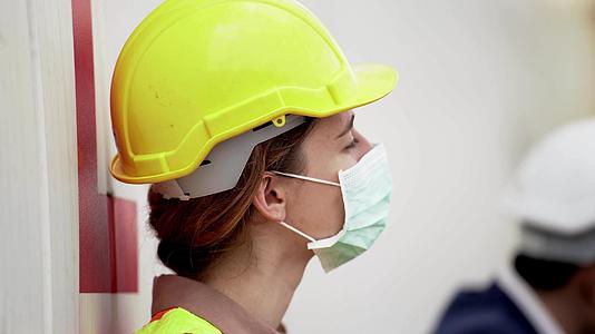 下班后劳工女工坐在室外仓库工厂放松工业工人戴防护口罩视频的预览图