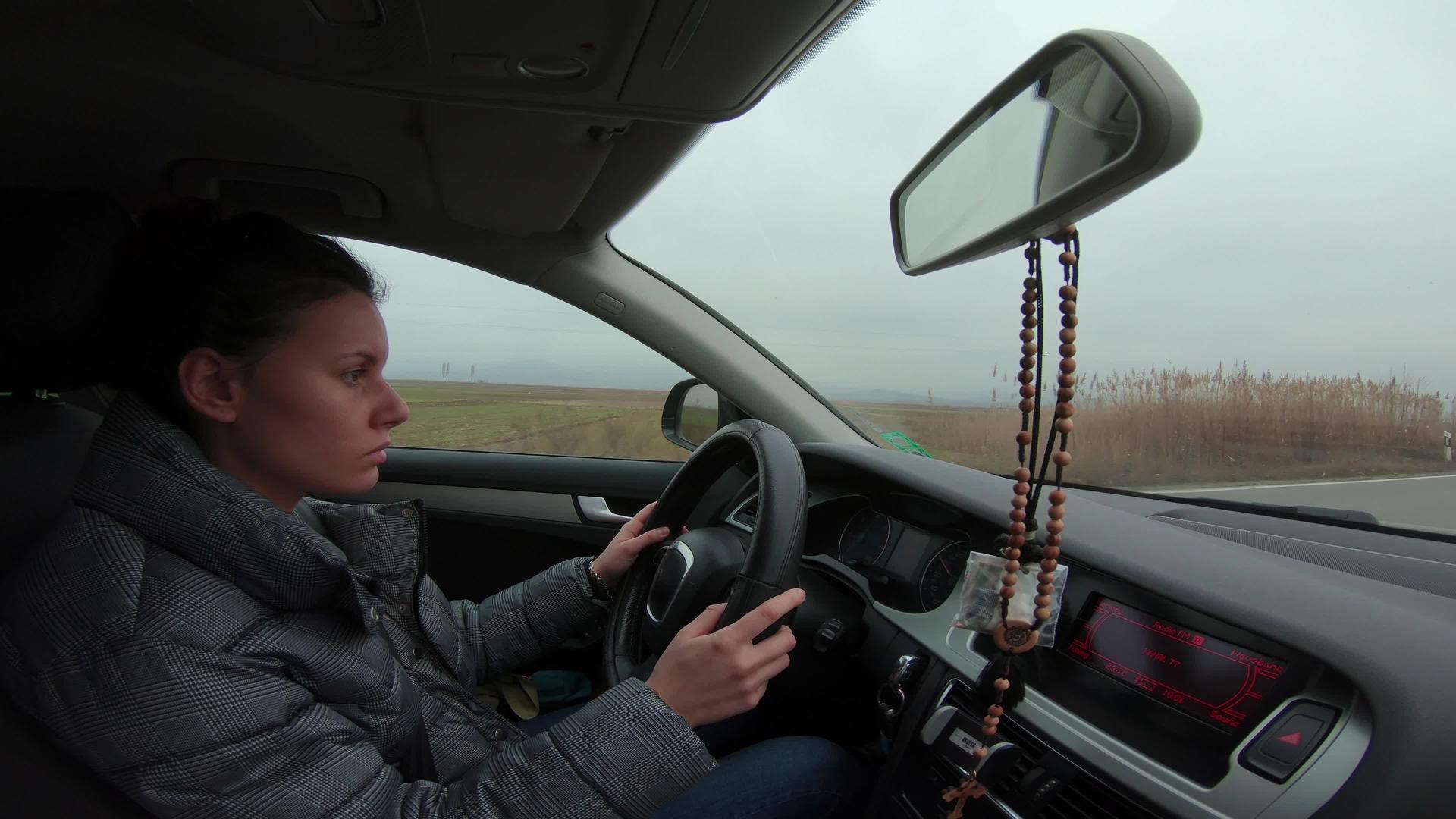 在雾中路上驾驶豪华轿车的年轻美女视频的预览图