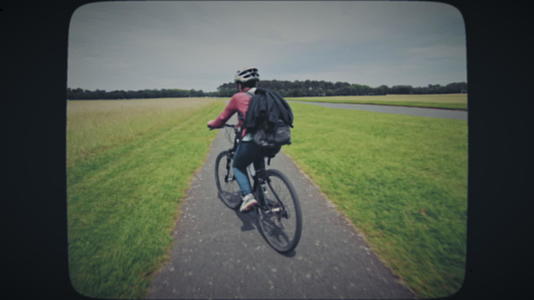 女人骑自行车穿越田野视频的预览图