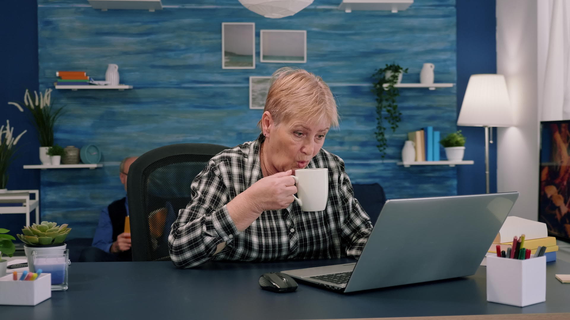 在笔记本电脑上工作时享受咖啡的老年妇女视频的预览图