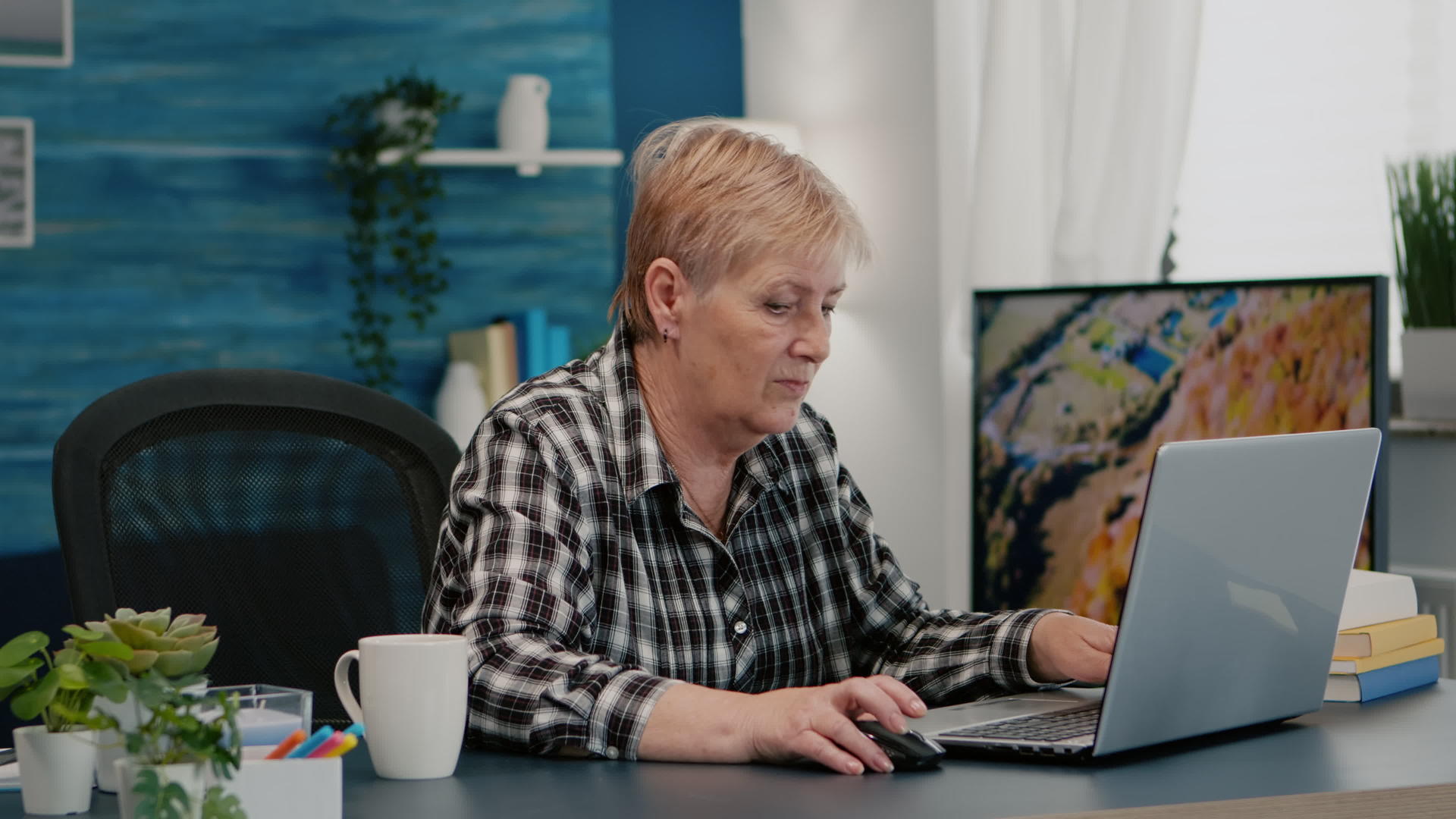 在家从事膝盖计算机工作的老年妇女视频的预览图