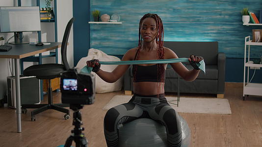 用录像机在网上瑜伽课上录制黑皮运动强壮的女人视频的预览图