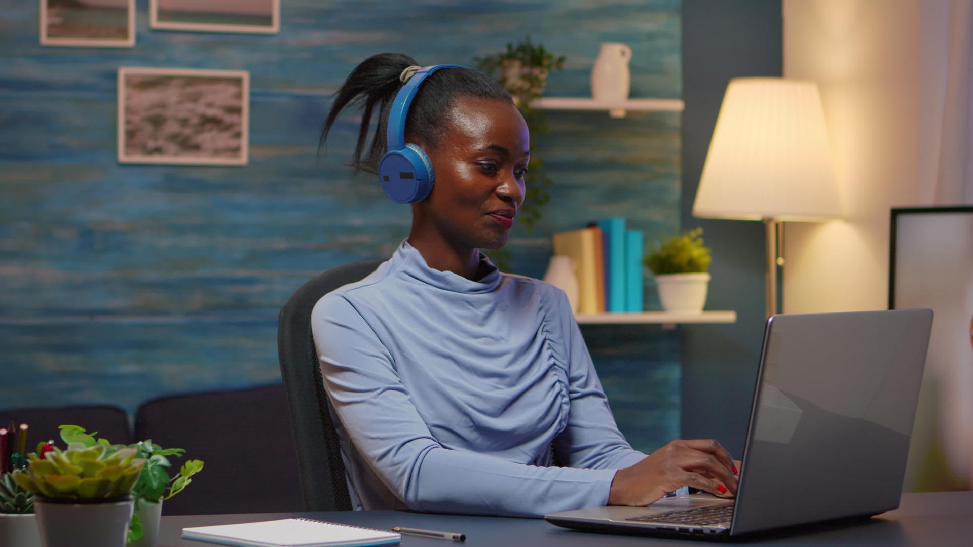 黑人设计师女性戴着耳朵听音乐的耳机微笑视频的预览图