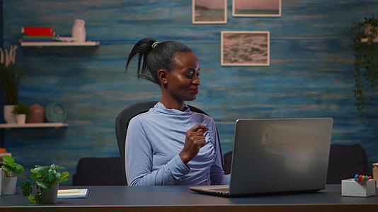 非洲自由职业记者在笔记本电脑上听音乐视频的预览图