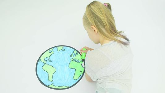 在世界地图上染色的年轻女孩视频的预览图