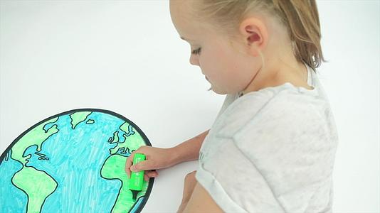 年轻的前天主教女孩在世界地图上染色视频的预览图