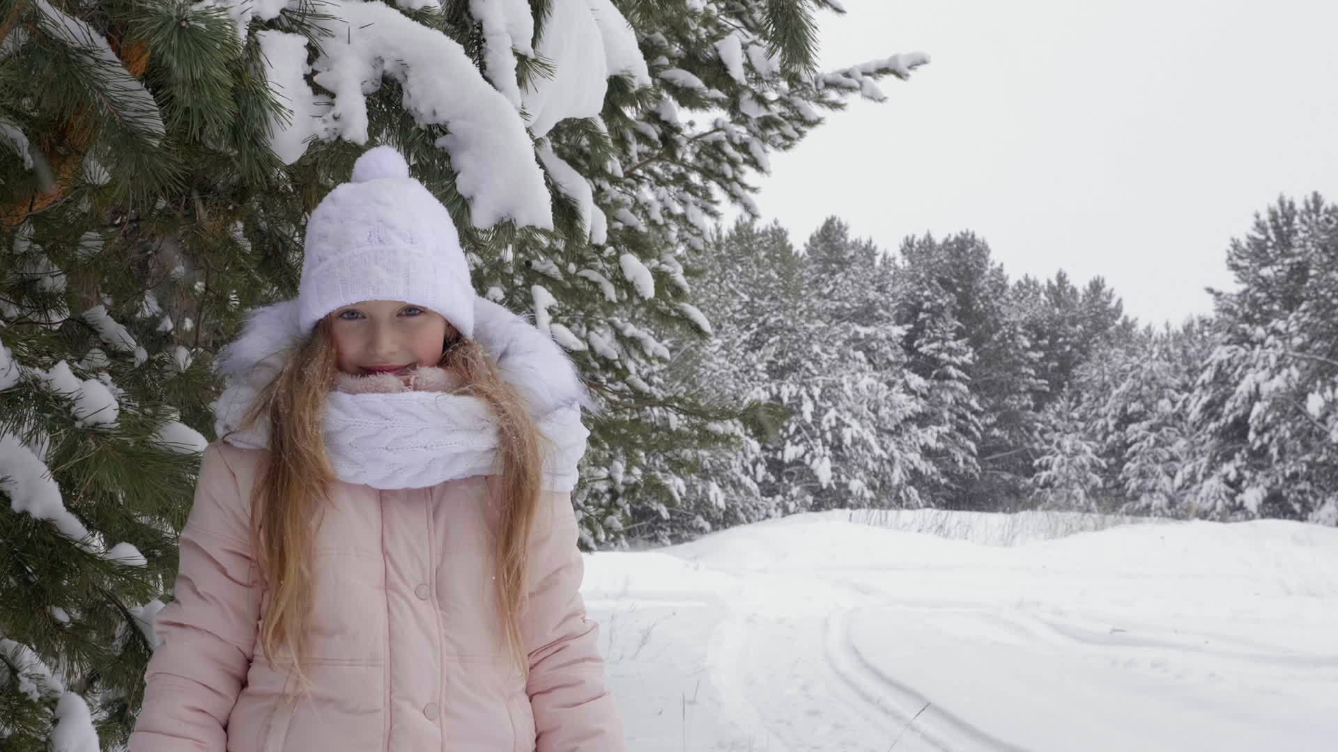 在冬天的森林雪中快乐的年轻女孩抬头看着相机视频的预览图