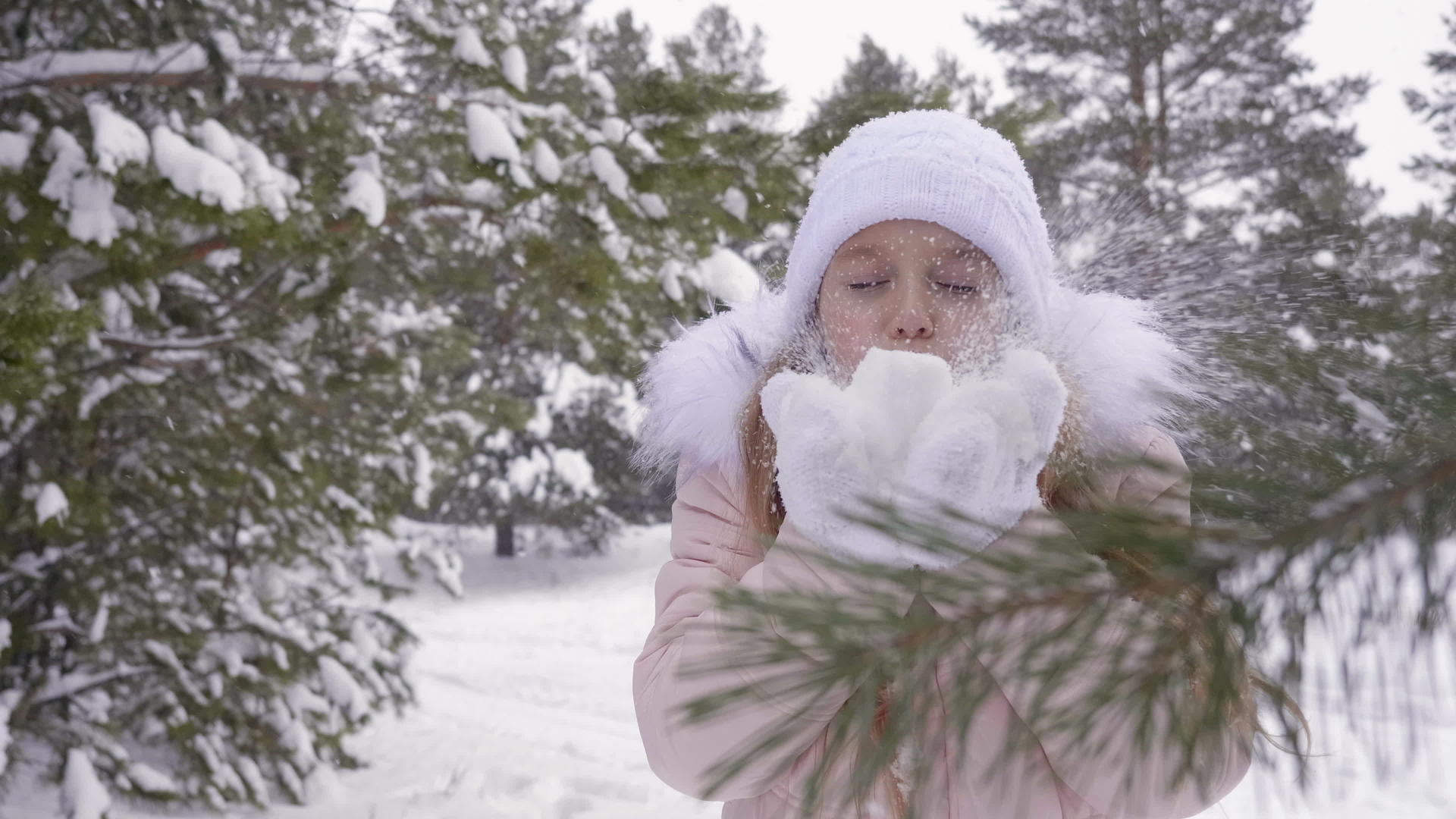 冬天年轻的女孩在寒冷的森林里扔雪视频的预览图