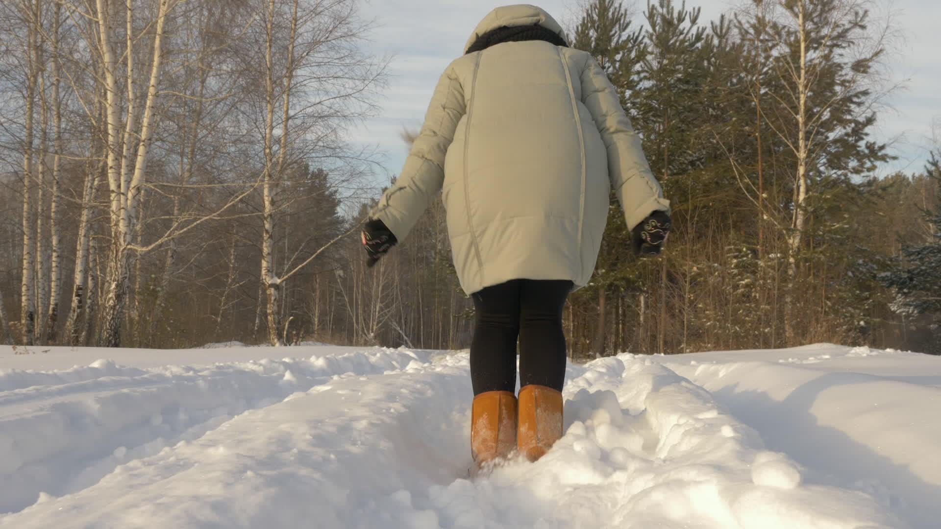 快乐的女人在雪林中奔跑在寒冷的冬天的冰霜中慢慢地走着视频的预览图