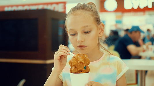 女孩吃美味的甜点冰淇淋咖啡馆里有泡泡松饼视频的预览图