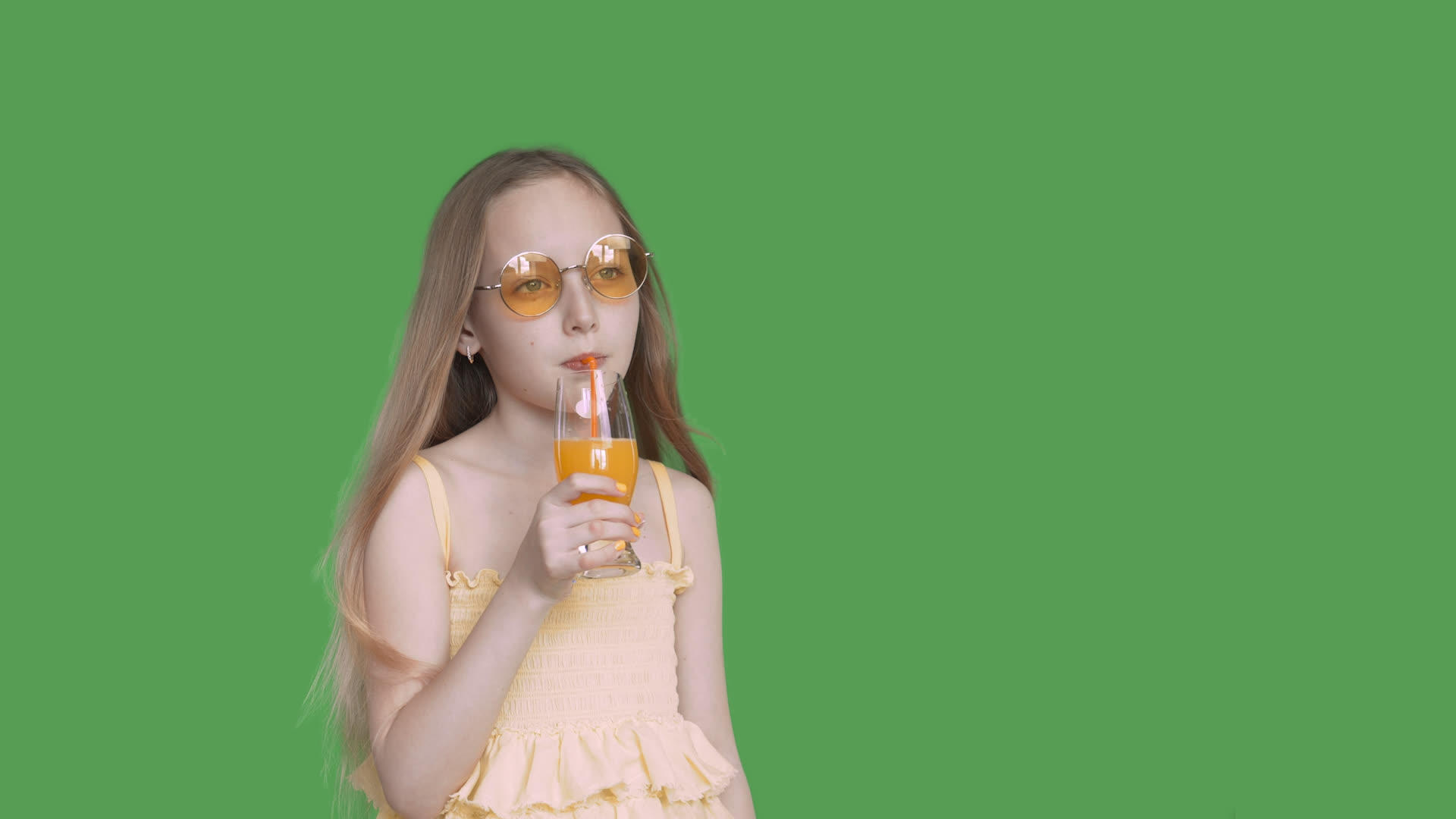 小女孩从杯子里喝橙汁视频的预览图