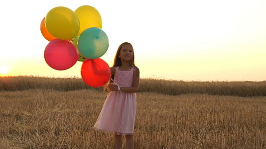 穿着彩色芭蕾舞团的年轻女孩在田野里奔跑视频的预览图