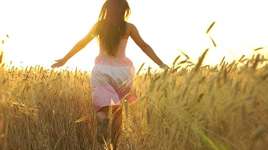 穿着裙子的漂亮女孩在田野里奔跑自由的概念视频的预览图