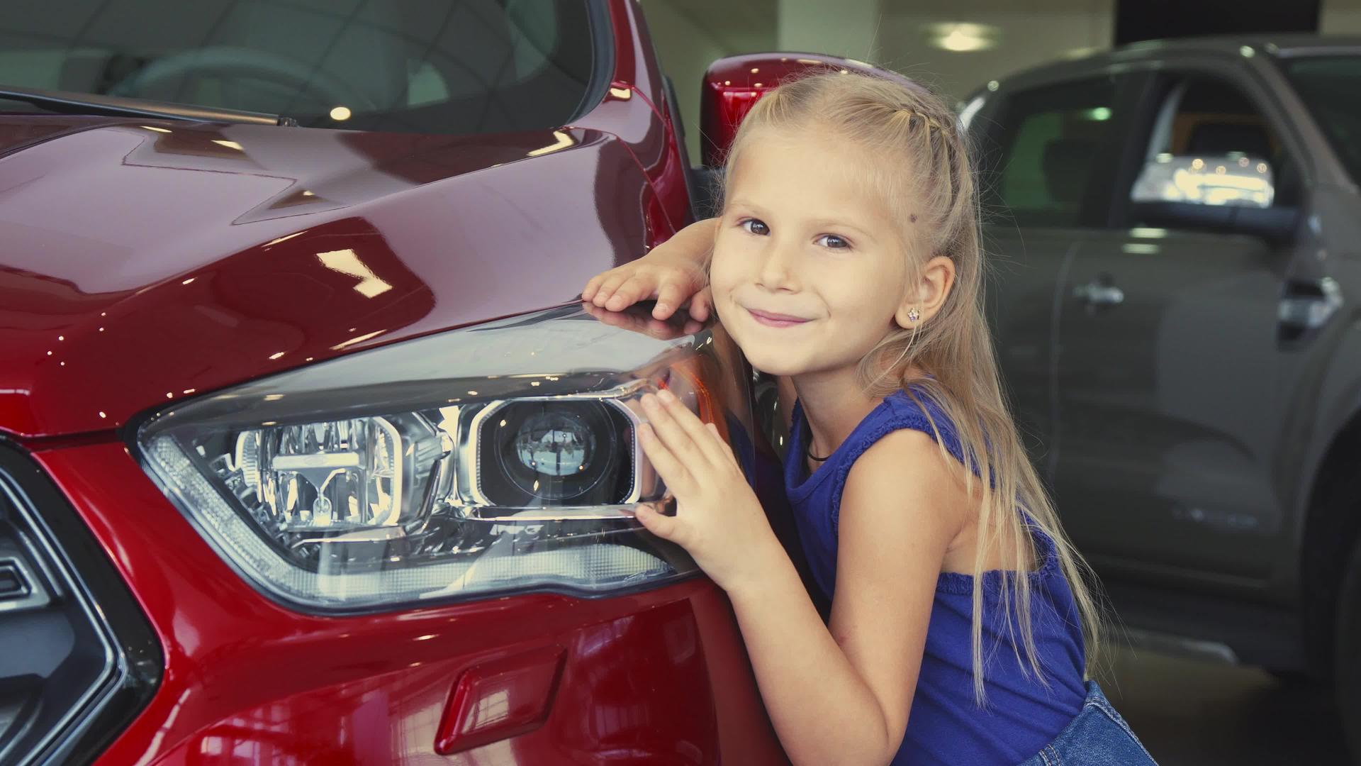这个漂亮的小女孩是一个在汽车背景上摆姿势的女孩视频的预览图