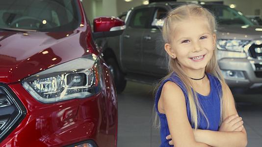 一个甜美的女孩站在汽车的背景和笑声上视频的预览图