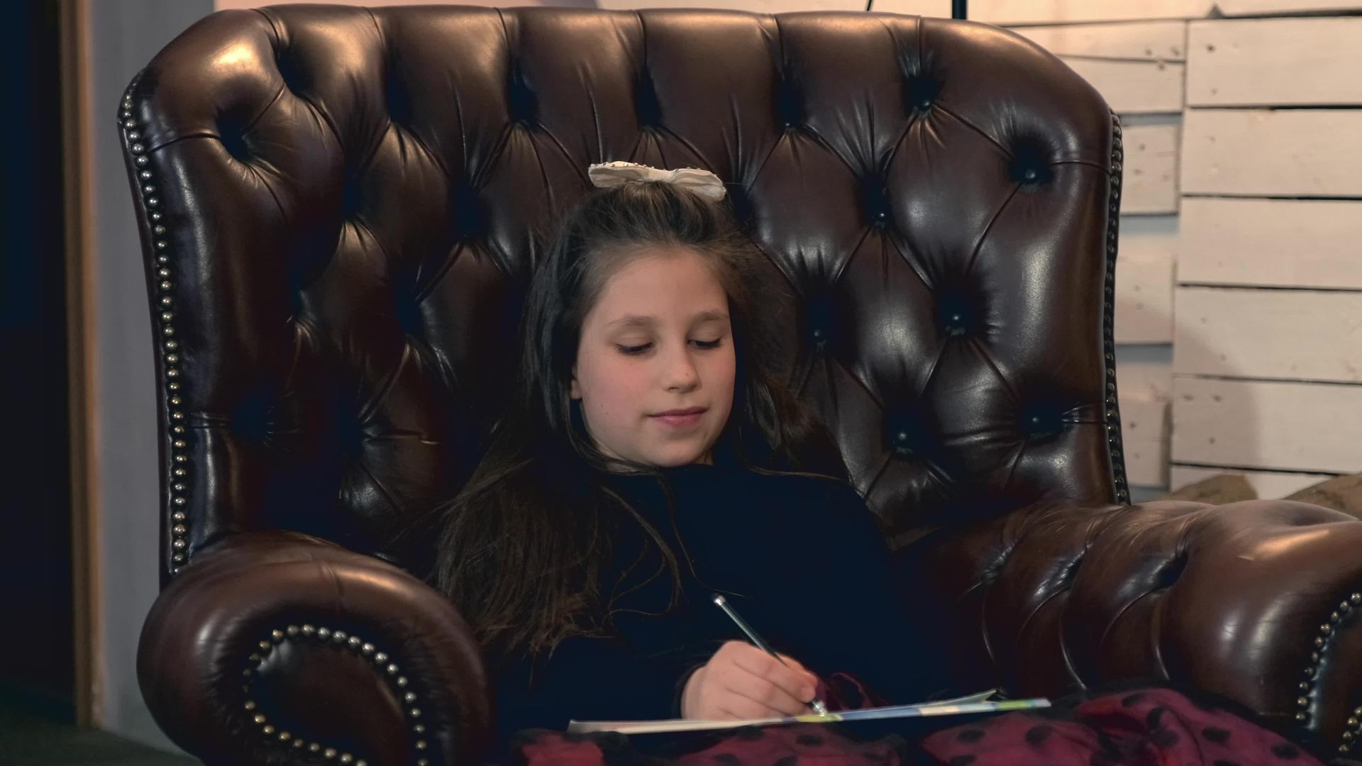 坐在皮臂椅上的漂亮女孩画了一张照片视频的预览图