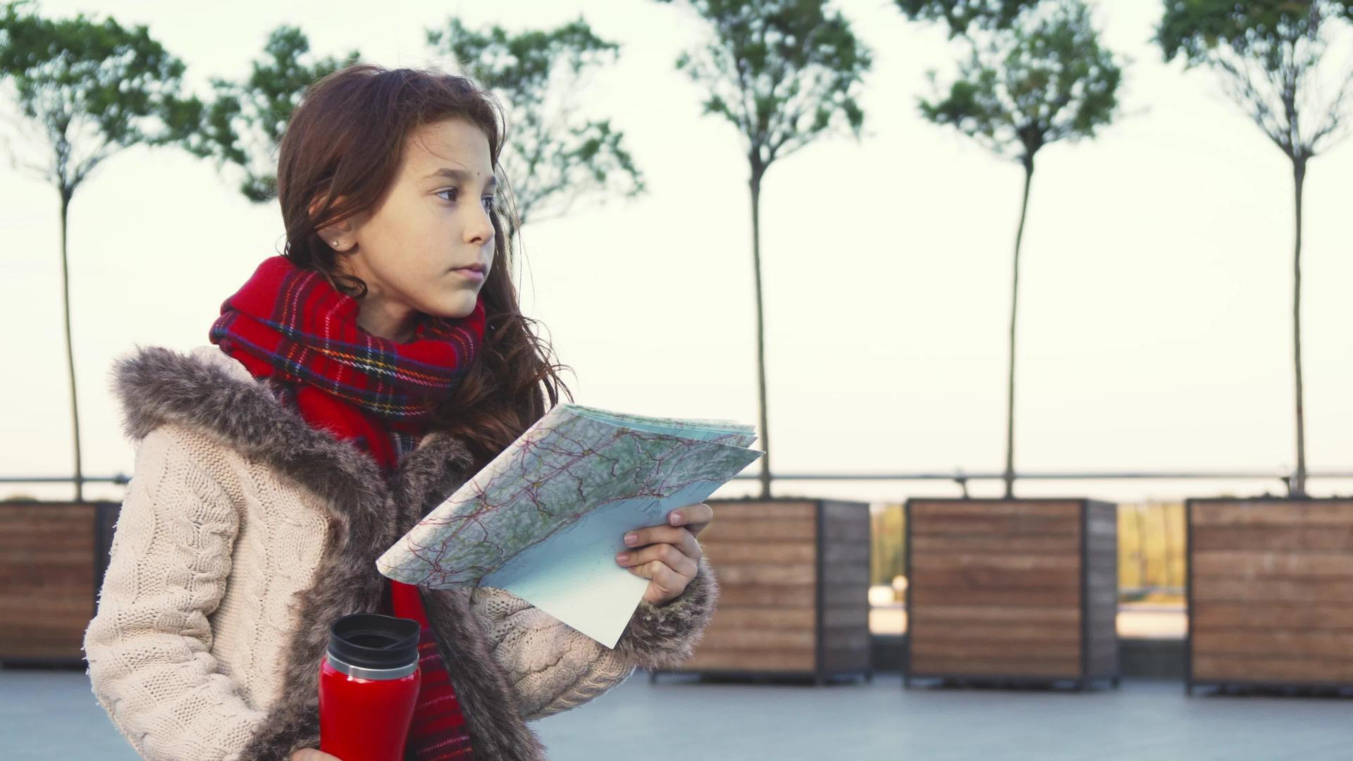 一个小女孩正在研究地图梦想着远处的视线视频的预览图