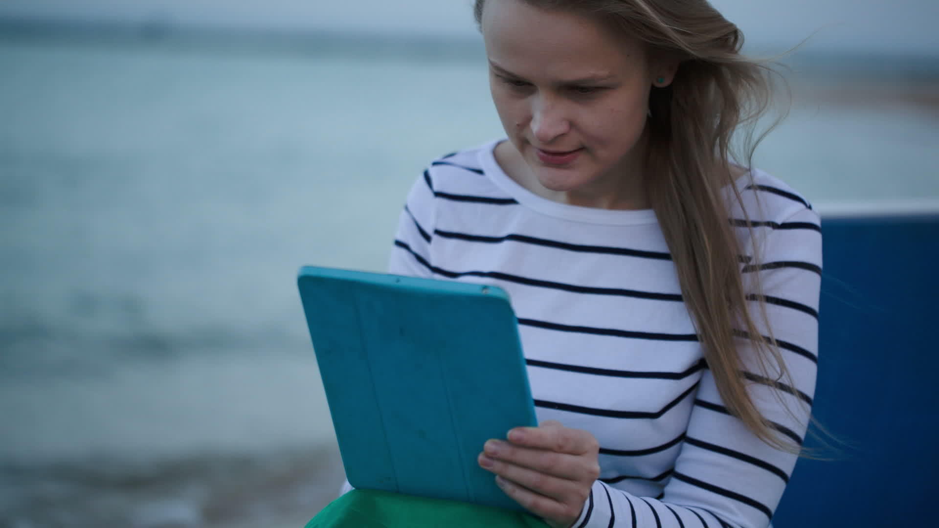 年轻女性在海边使用平板电脑视频的预览图