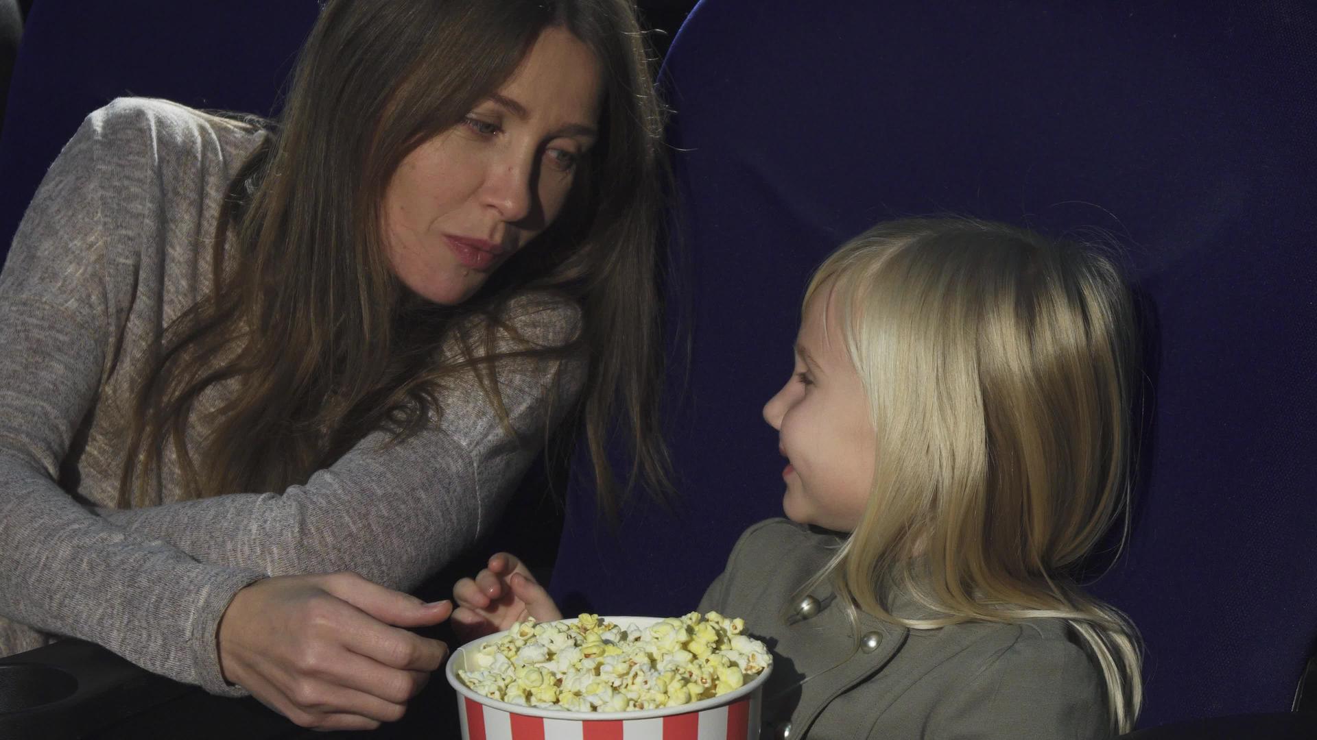 可爱的小女孩在电影院给妈妈喂爆米花视频的预览图