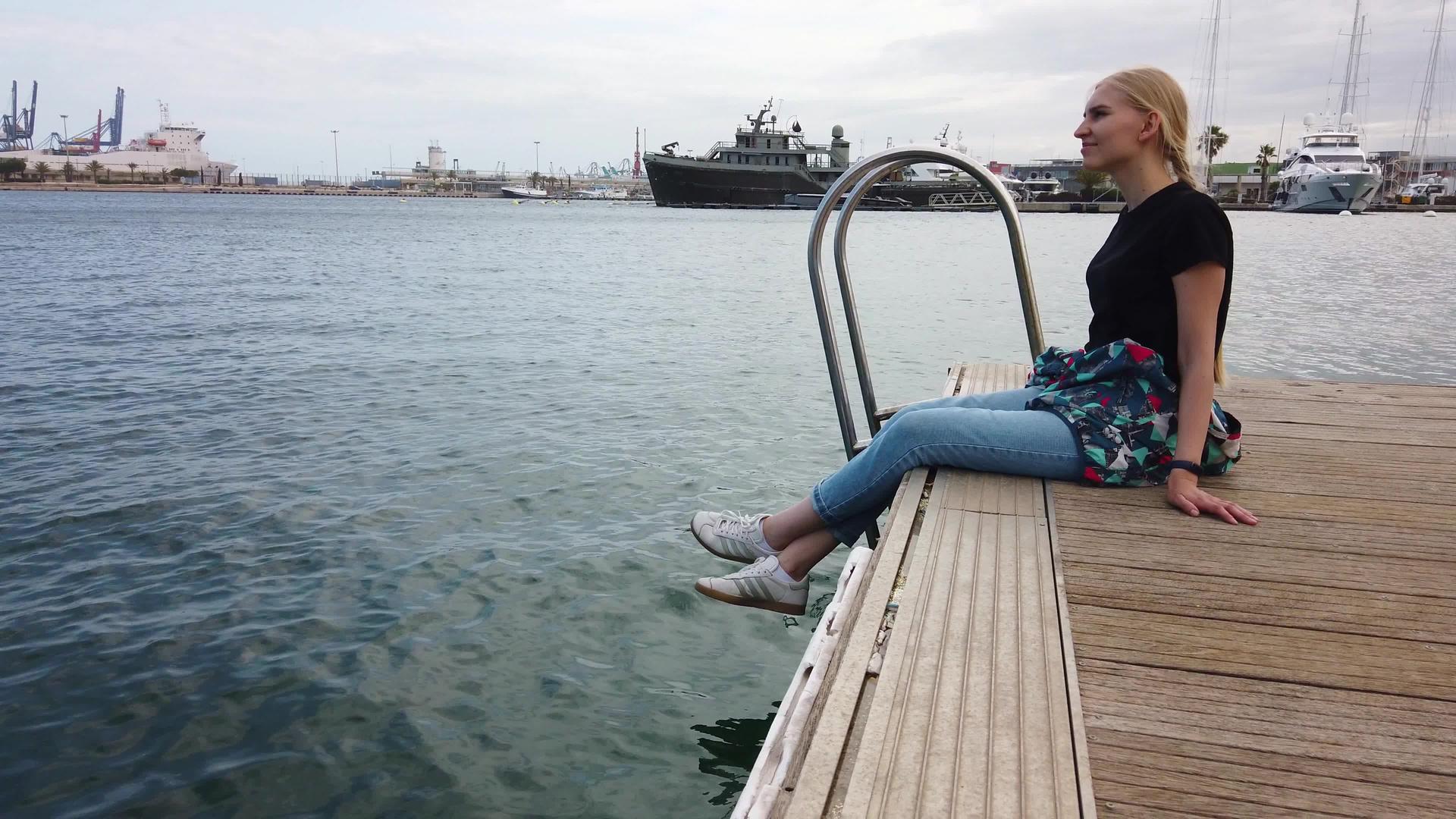 独自坐在码头岸边的女孩视频的预览图