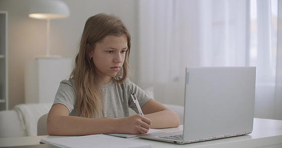 女孩在很远的地方学习写练习书看笔记本的展示呆在家里视频的预览图