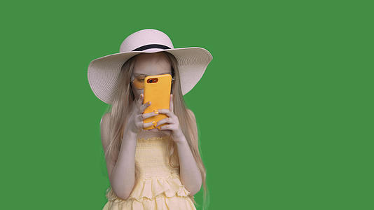 穿着夏帽和衣服的女孩正在浏览电话视频的预览图