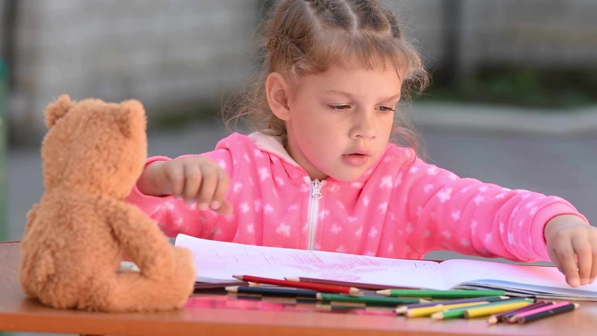 五岁的女孩正在选择她想要的彩色铅笔画视频的预览图