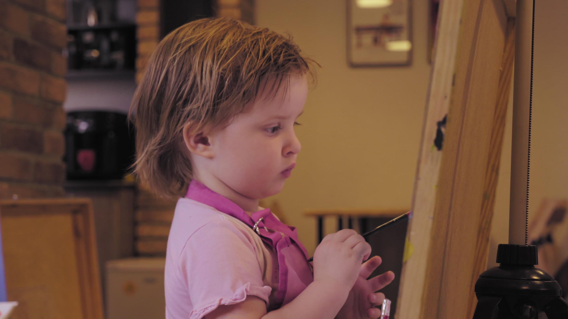 小女孩在画室的画布上微笑着画画视频的预览图