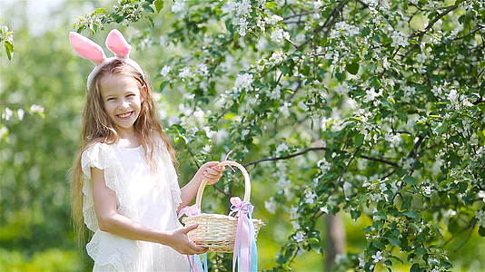 可爱的小女孩在美丽的春天盛开的苹果花园视频的预览图