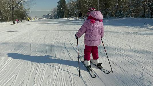 小女孩滑下滑雪坡冲向中间视频的预览图