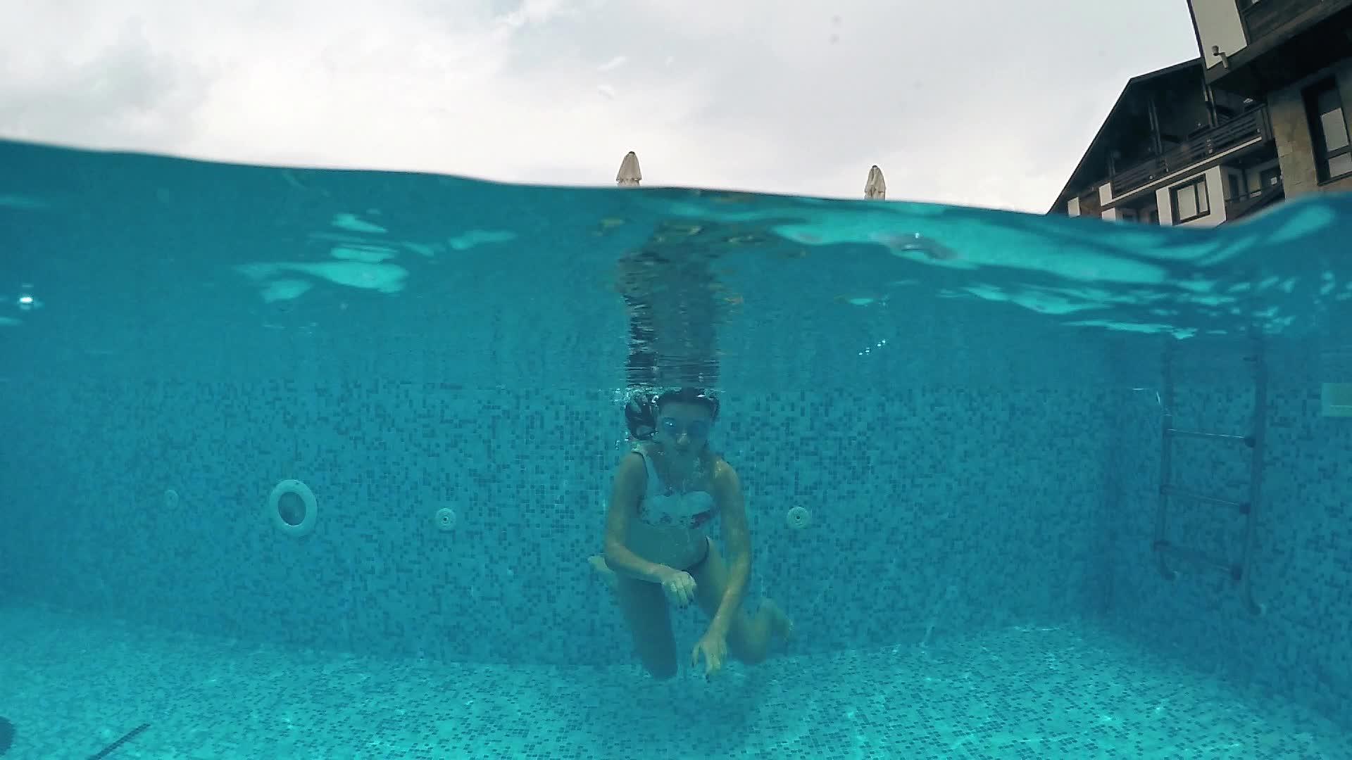 年轻少年有谷歌在户外游泳池潜水戈普罗圆顶拍摄慢动作视频的预览图