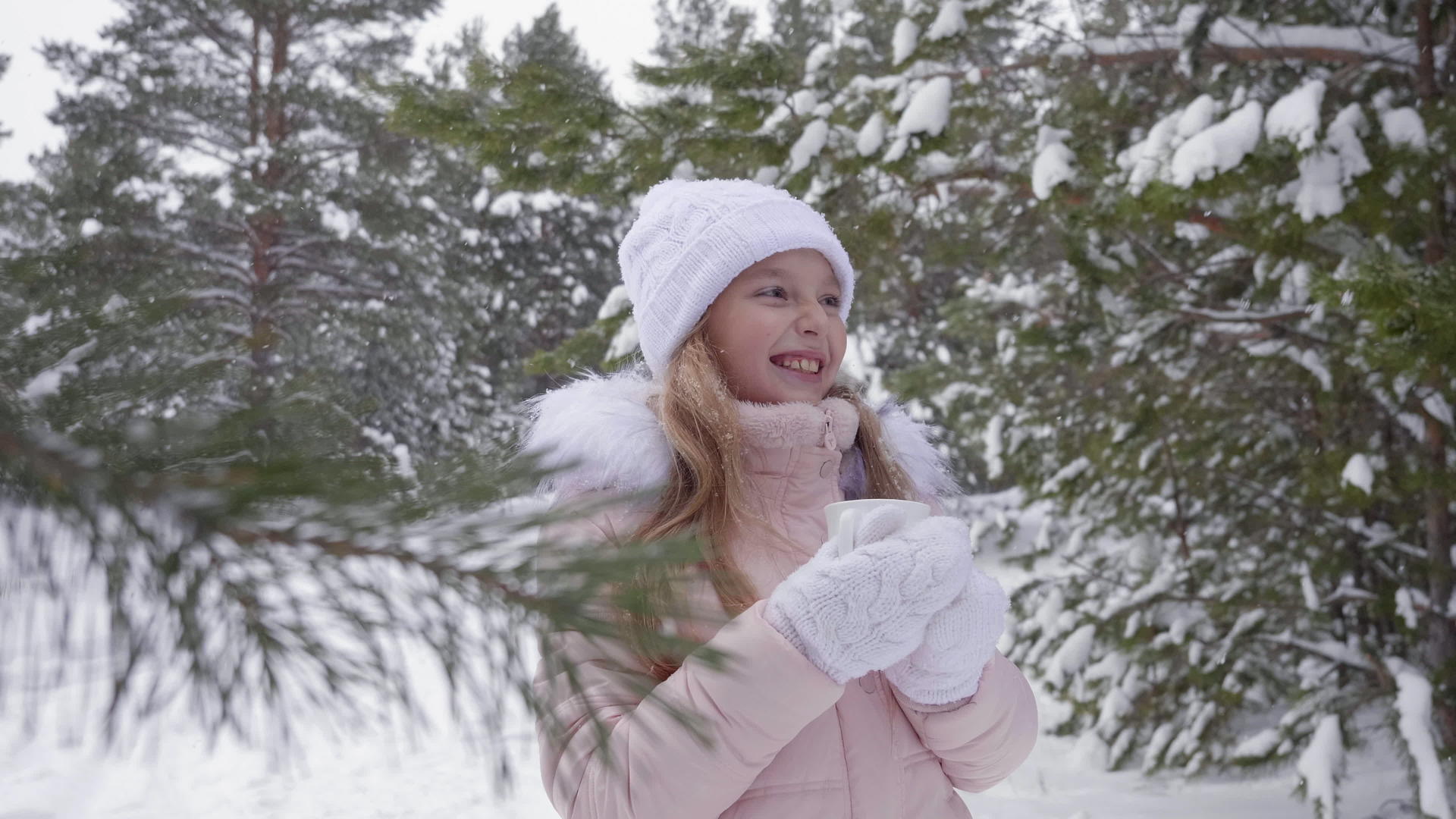 可爱的女孩在雪地树林里微笑视频的预览图