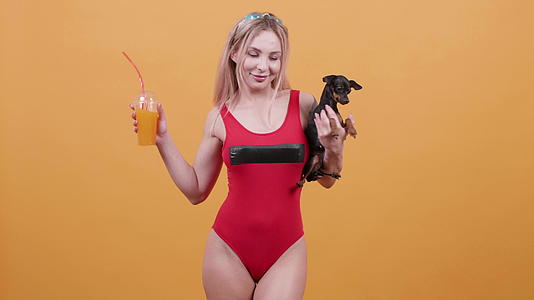 性感的金发色泳衣的性感金发美女一只手拿着鸡尾酒另一只手拿着鸡尾酒视频的预览图
