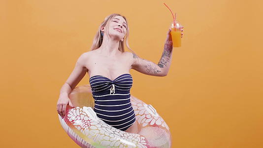 一个年轻性感的金发美女的肖像鸡尾酒和游泳环视频的预览图