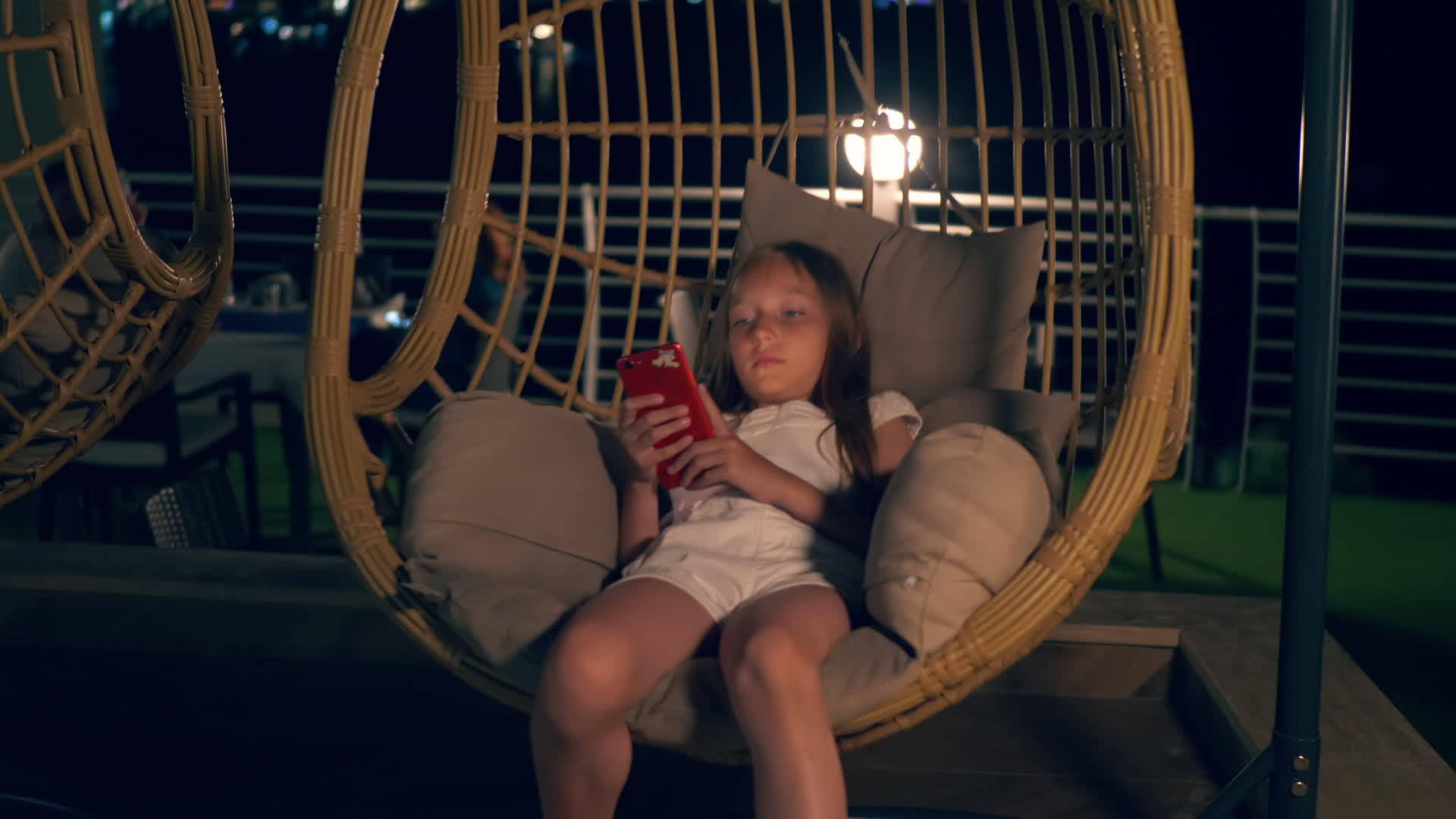 智能手机女孩在椰子摇椅上休息视频的预览图