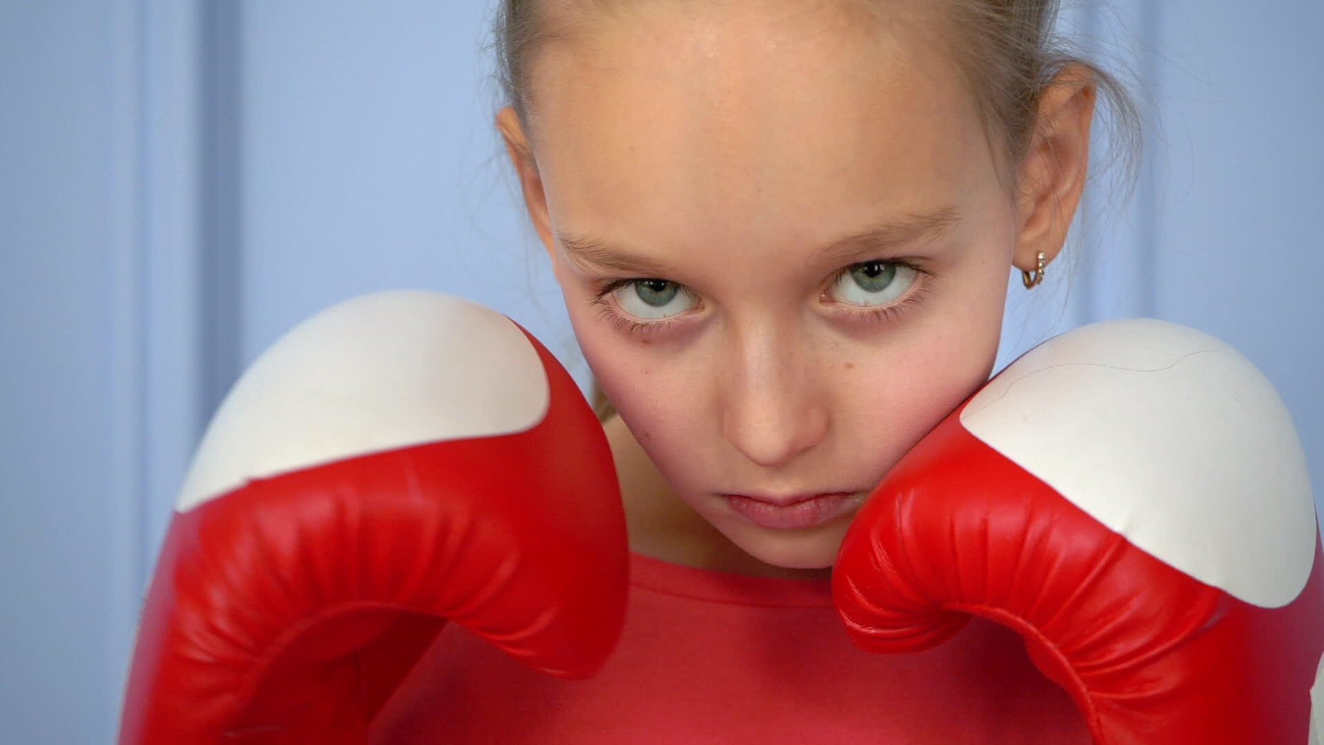 特写运动年轻女孩直接击中并孤立在蓝色背景下进行拳击练习视频的预览图