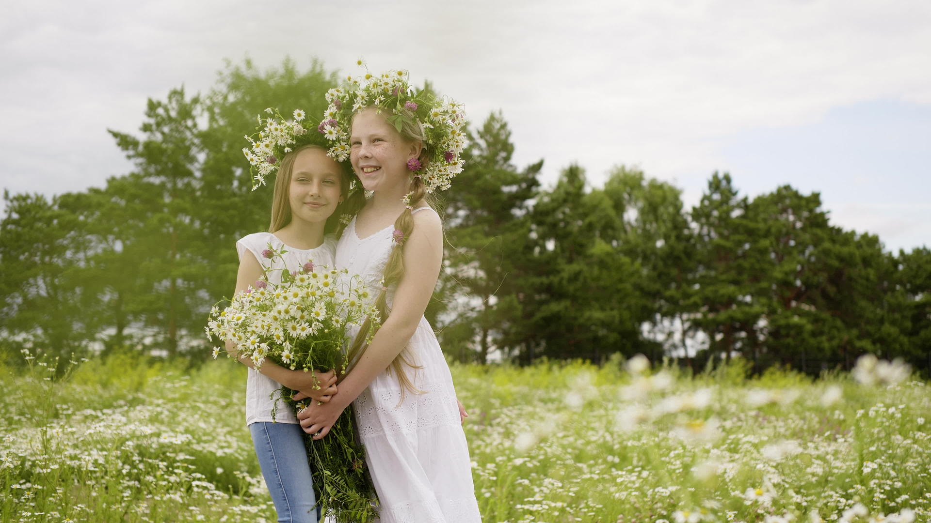 两个女朋友拥抱着花圈和花束把她们放在绿色的田野里视频的预览图