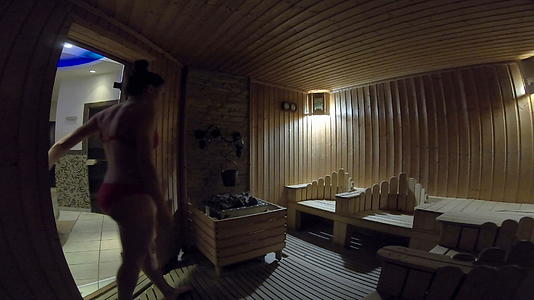 穿着泳衣的女孩进入木管室桑拿室放松和休息视频的预览图