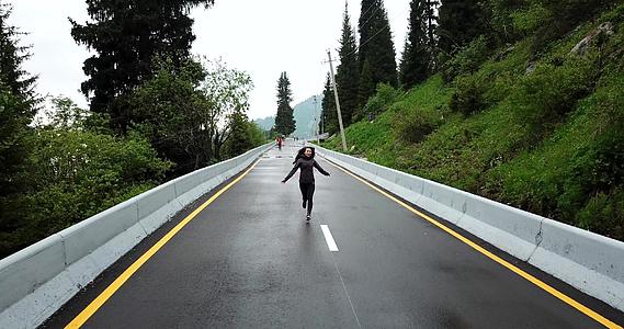 一个女孩在山上用湿沥青跑来跑去视频的预览图