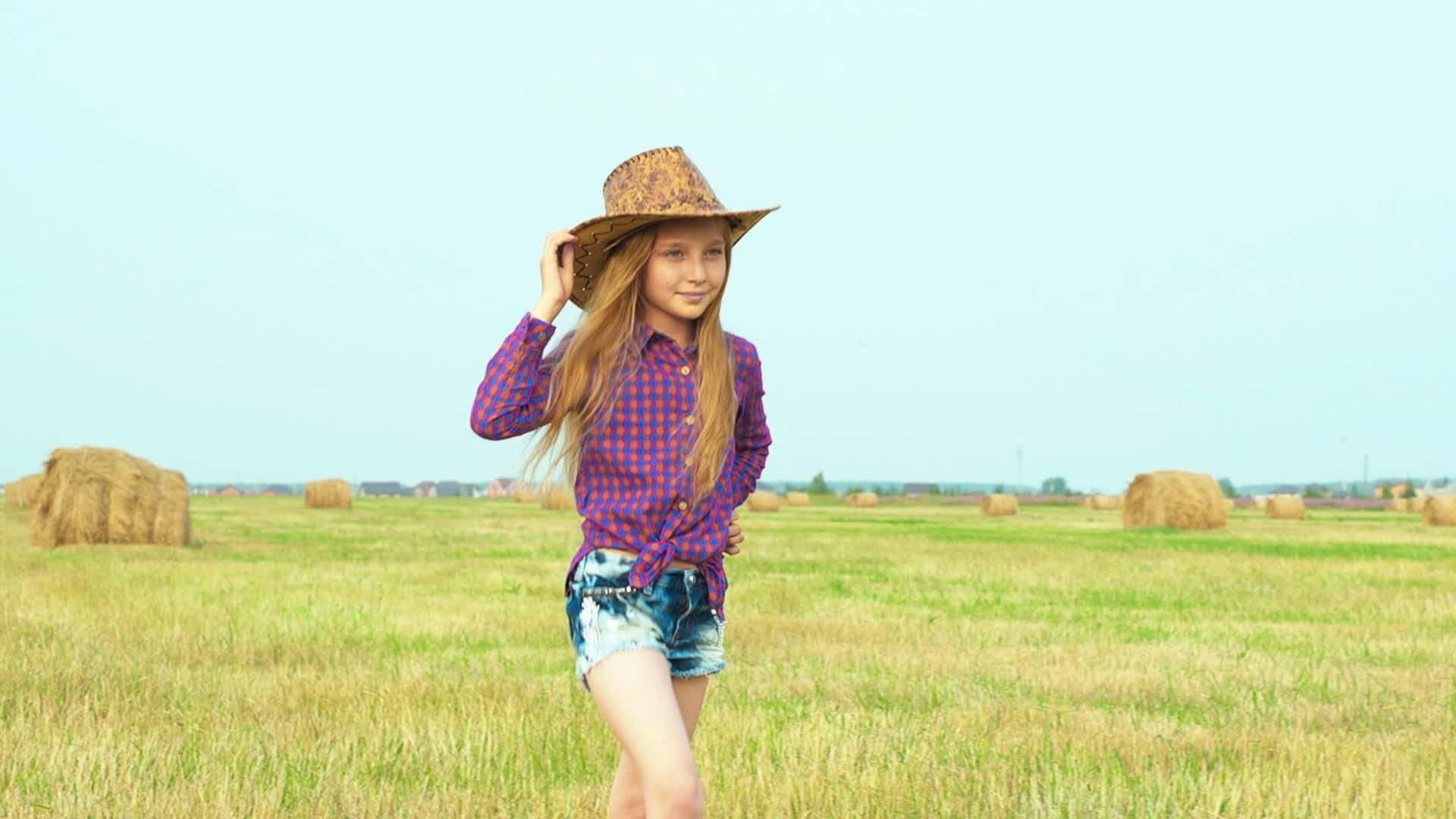 女孩在农村的田野里走着干草堆在里面视频的预览图