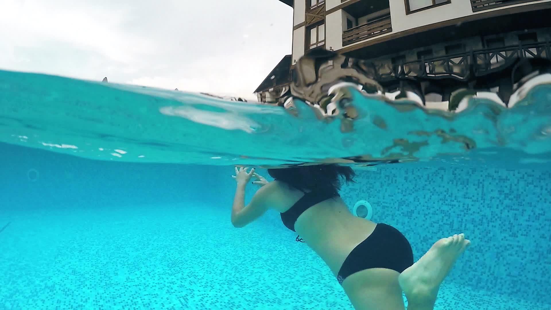 快乐的女孩游过豪华的游泳池视频的预览图