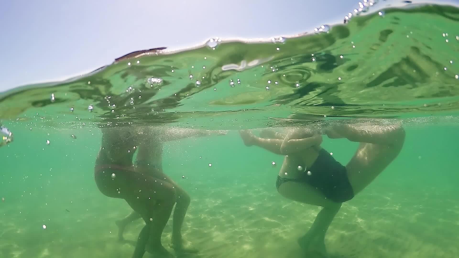 年轻女孩在绿色的海水中欢笑和玩耍GOPRO圆顶半水下视频的预览图